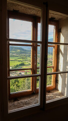 Panoramic view to the Bled town and surrounding mountains through a window