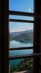 Panoramic view to the lake Bled and surrounding mountains through a window