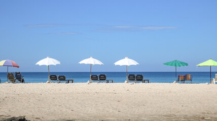 Beach chairs and beach umbrella on sand.