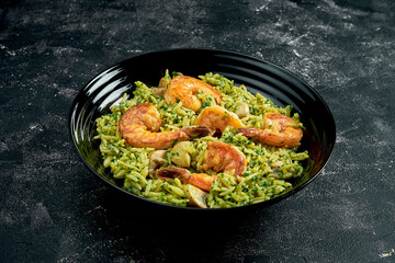 Wok rice with shrimps on a black stone background. 45 degree angle view. Close-up, selective focus