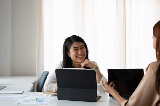 Asian female advisor meeting with customer financial. Young beautiful candidate at job interview in modern office space. Business consulting or employment concept.
