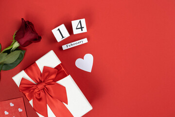 Valentine's day flat lay on red background. Valentine's day background: February 14, flowers, gift, white heart on a red background, top view, copy space