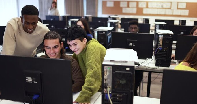 Young multiracial students learning together inside computer classroom