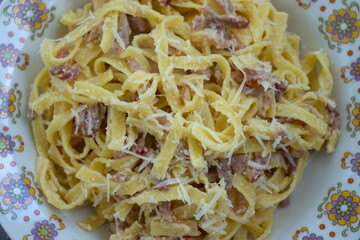 Carbonara pasta with bacon and cheese and tagliatelle
