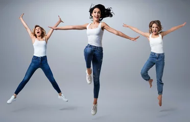 Foto op Canvas Group of beautiful  young women wearing white shirt and denim jeans having fun © konradbak