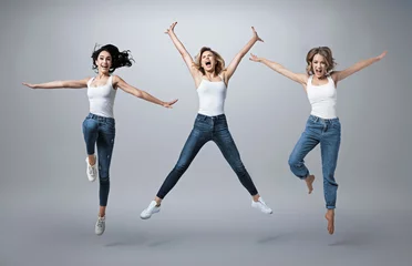 Foto auf Alu-Dibond Group of beautiful  young women wearing white shirt and denim jeans having fun © konradbak