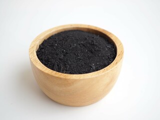 Charcoal powder in wooden bowl  isolate on white background. closeup photo.