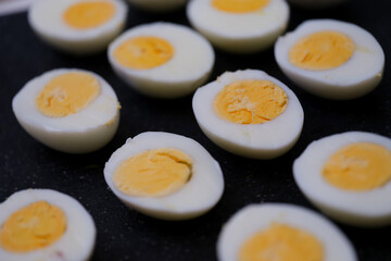 Halves of boiled chicken eggs on a black background