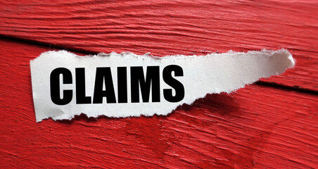 CLAIMS word on a small sheet of paper and a red table. - obrazy, fototapety, plakaty