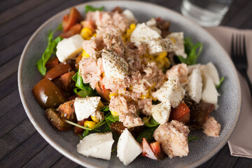Plate of salad with tuna, corn, tomatoes and arugula