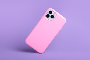 Smartphone iPhone 11 and 12 Pro max in pink silicone case falls down back view, phone case mockup...
