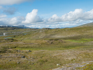 Beatiful northern artic landscape, tundra in Swedish Lapland with blue Duottar lake, green hills and mountains at Padjelantaleden hiking trail. Summer day, blue sky, white clouds