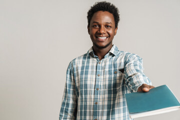 Black unshaven man in plaid shirt posing with exercise book