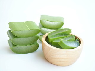 Aloe vera sliced in wooden bowl on white background. closeup photo, blurred.