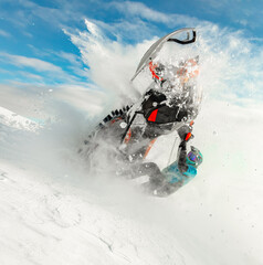 extreme driving of a mountain snowmobile. a sports snowmobiler in bright clothes and a helmet without brands, a colorful snowmobile of a new model. jumping with plumes and whirlwinds of snow