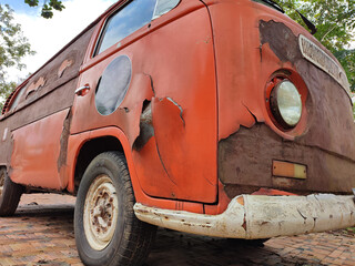An abandoned orange car, or old van. old car was left corrosive. 