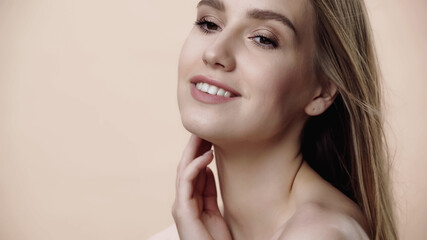 cheerful young woman with makeup isolated on beige.