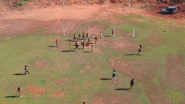 Indigenous Australian Aboriginal people Playing Australian Football Rules (AFL) on the Tiwi Islands on a Remote Island off of Northern Territory Australia