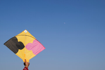 Female flying kite with sky background on occasion of Indian kite flying festival of Makar...