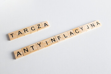 Tarcza antyinflacyjna, napis z drewnianych literek na jednloitym tle