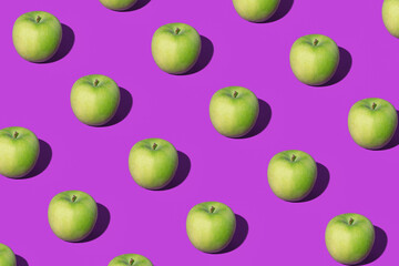 Pattern made of green apples on purple background. Minimal fruit concept. Apples pattern on ultra violet background. Fruit mood. Healthy food. Flat lay.