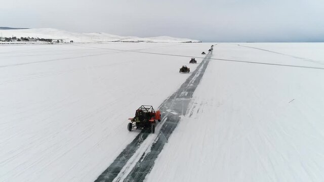 Buggy rides on the ice of frozen Lake Baikal. Homemade buggy rushes at high speed along the icy road