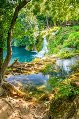 Fototapeta premium Waterfalls at Krka river, Croatia. Part of the Skradinski Buk waterfall. Famous place in nature park - beautiful tourist destination in Croatia. Fresh green nature, summer weather.