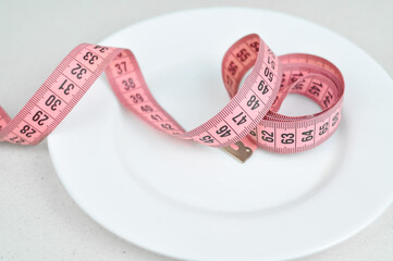 Pink tape measure and green vegetables diet concept