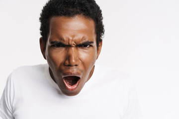Obraz premium Young black man in t-shirt frowning while screaming at camera