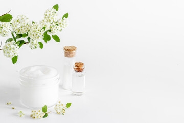 Obraz na płótnie Canvas White moisturizing cream cosmetic for spa treatment with blossoms flowers
