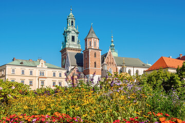 Wawel Royal Castle with flowers in the foreground and clear blue sky in the background, Krakow, Poland. View on a sunny October day.