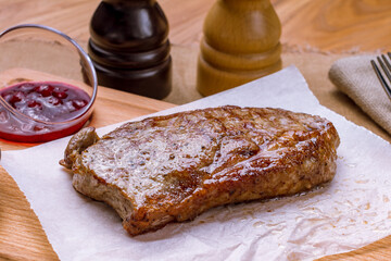 juicy Striploin Steak on wooden board with sauces