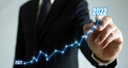 Business plan for increase in 2022 year.Business person draws increase arrow graph corporate future growth year 2021 to 2022. Development to success and motivation.New year with great achievements