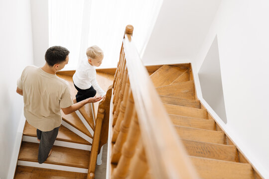 White Man And His Son Coming Up Stairs At Home