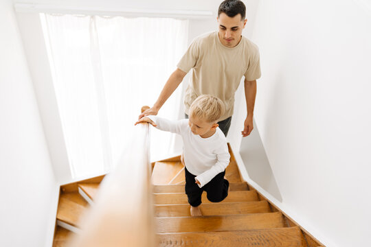 White Man And His Son Coming Up Stairs At Home