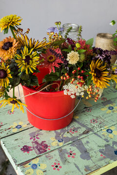 Bucket of harvested farm flowers on farm table