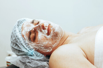 A young man lies with a mask on his face in a spa beauty salon. The concept of body and face care for men