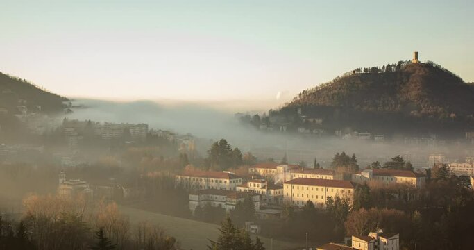 Italy - Time-lapse view of Baradello Castle and Como City wrapped in a morning winter fog