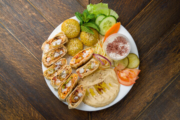 shawarma with chicken in Arabic with hummus and falafel balls top view on wooden table