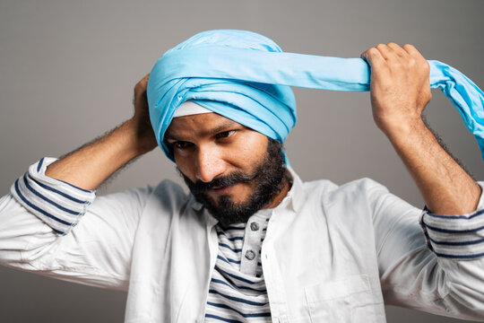 indian sikh man wearing treditional turban at grey background - concept of religion custume and identity.