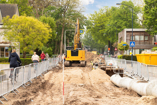 Construction of concrete pipelines for a sewage and wastewater system under a road in a built-up area.