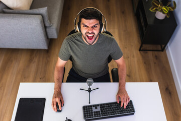 Angry designer in headphones at home office
