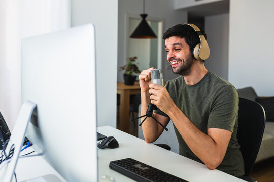 Designer in headphones at table speaking with the microphone