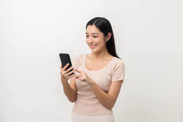 Excited Beautiful young asian woman using smartphone mobile standing on isolated white background. Playing game on smartphone winning victory moment. Very happy enjoy and fun relax time