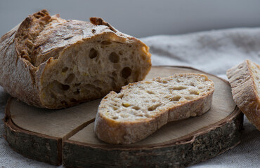 A slice of grain bread is lying on a wooden stand.