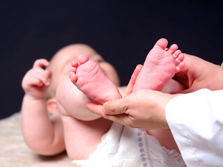 doctor checks the reflexes of a newborn baby on the sole of the foot