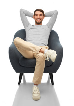 People And Furniture Concept - Happy Smiling Man Sitting In Chair Over White Background