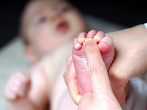 doctor checks the reflexes of a newborn baby on the sole of the foot