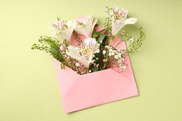 Pink envelope with flowers on green background