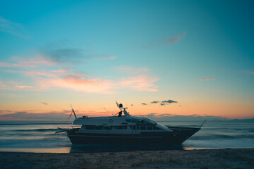 Fototapeta na wymiar boat aground on the beach with sunset colors